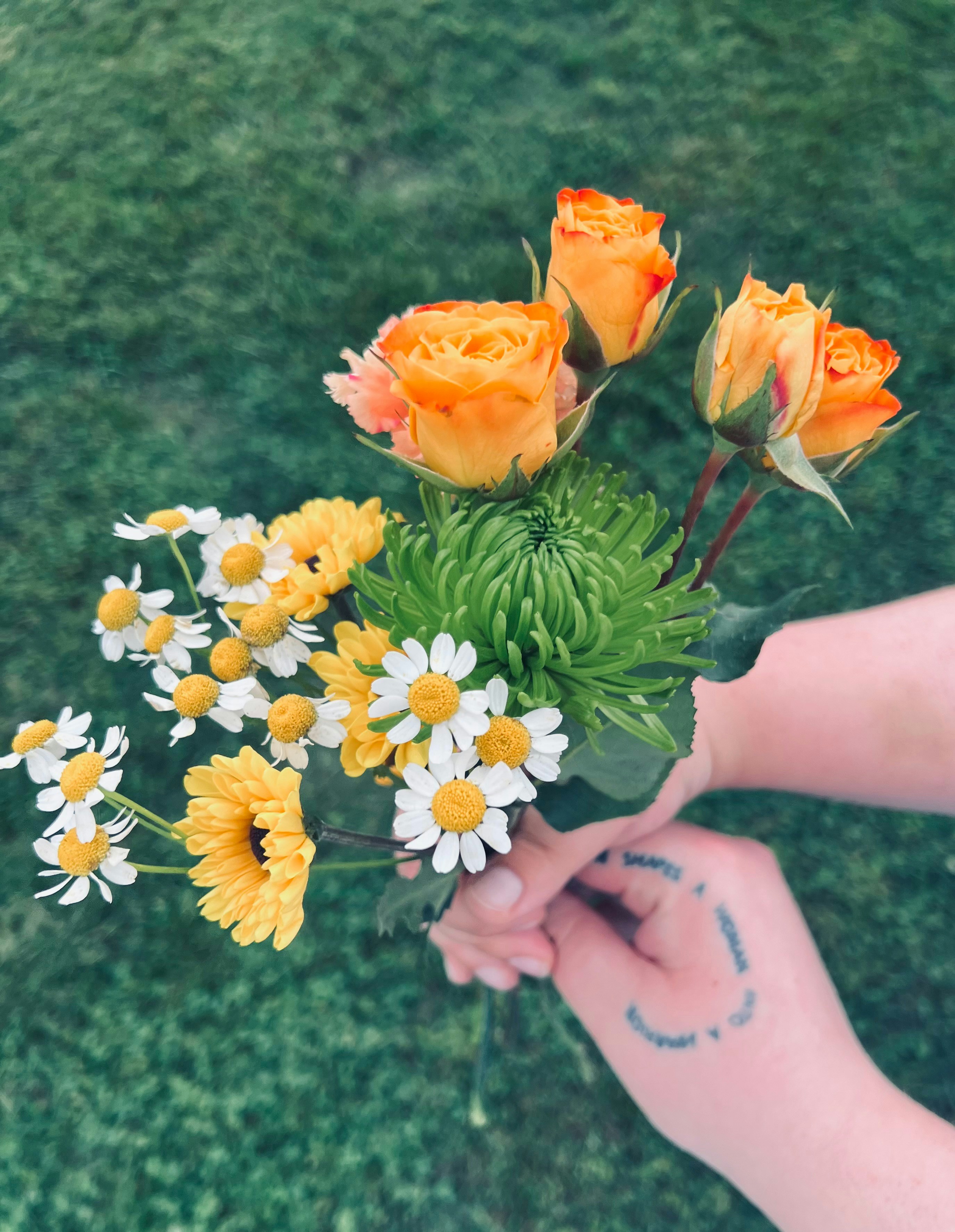 a person holding a bouquet of flowers in their hand