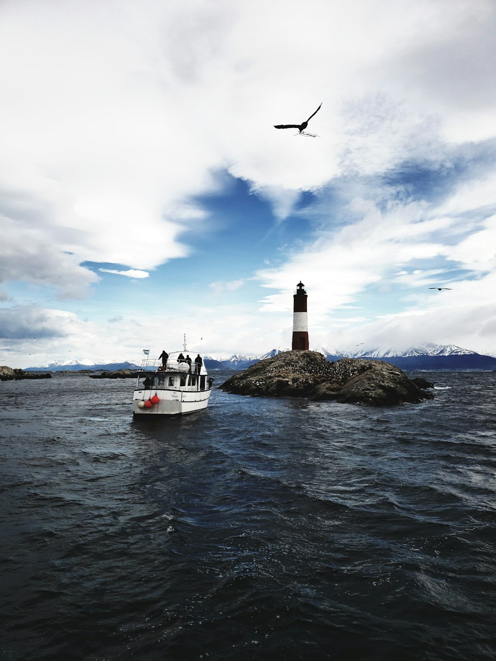 a boat is in the water near a light house