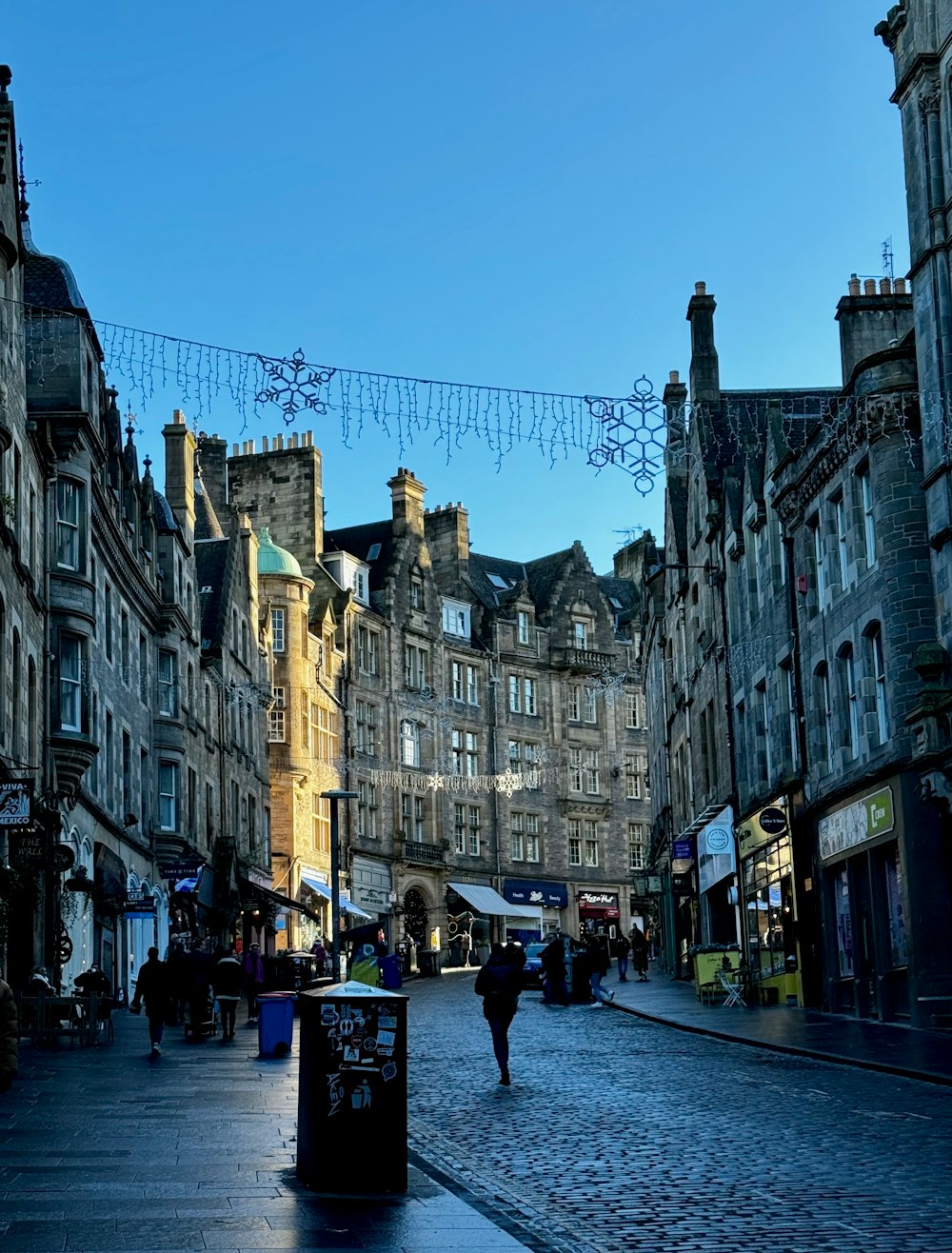 a person walking down a cobblestone street in a city