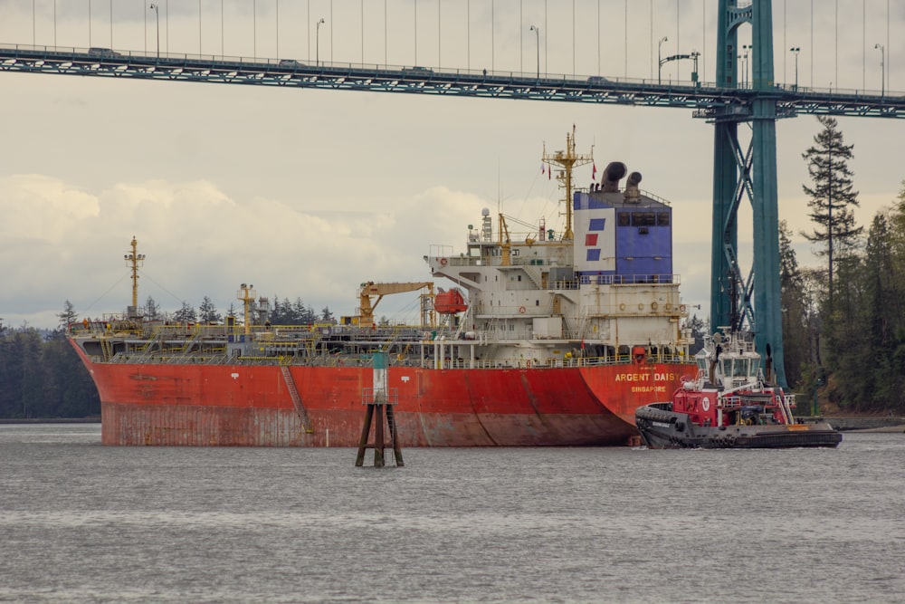 a large red boat sitting in the middle of a body of water