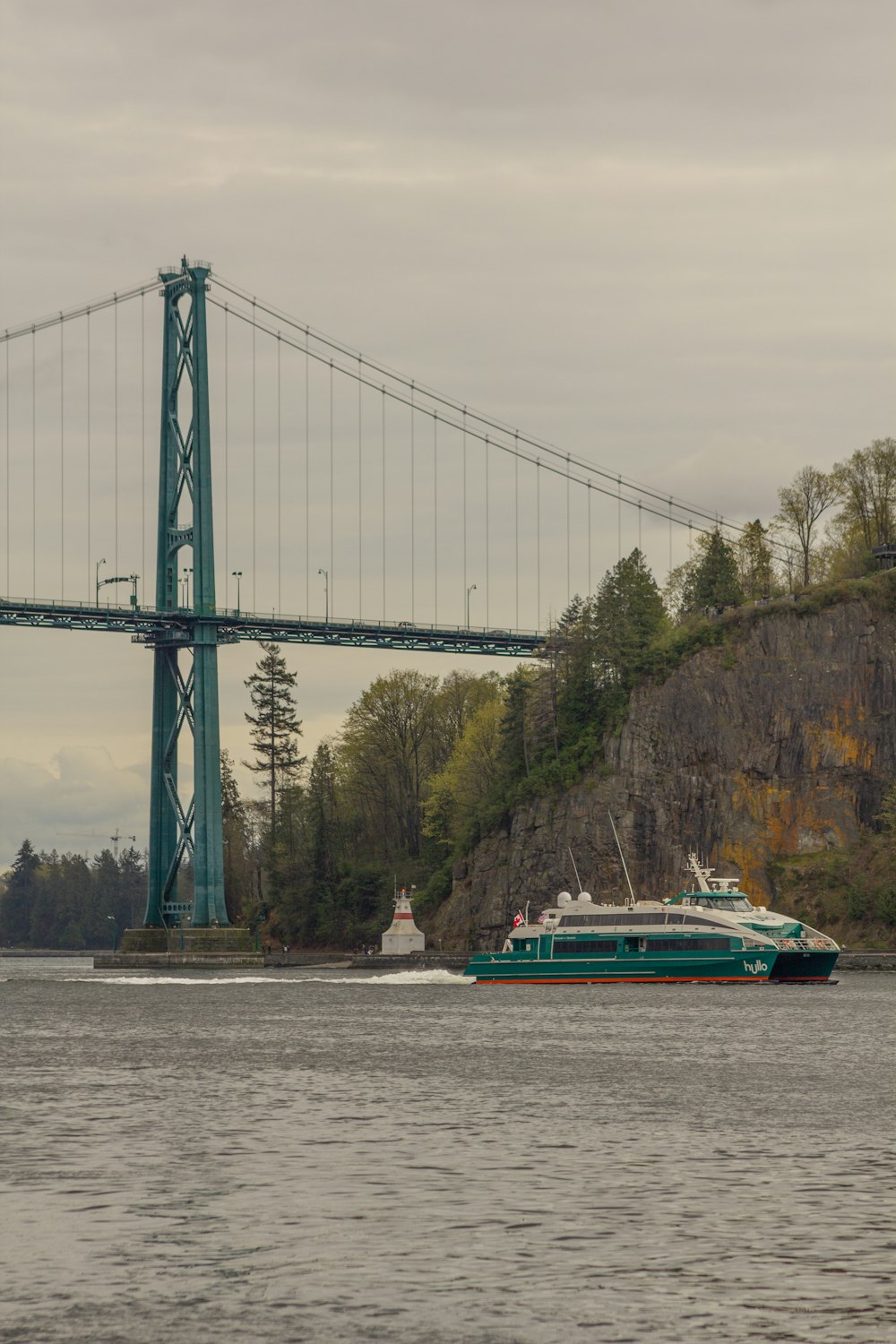 a boat traveling under a bridge on the water