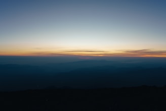 the sun is setting over a mountain range