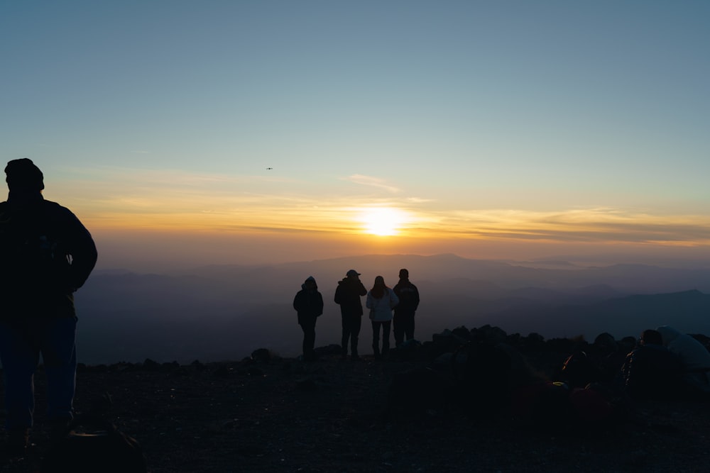 a group of people standing on top of a mountain