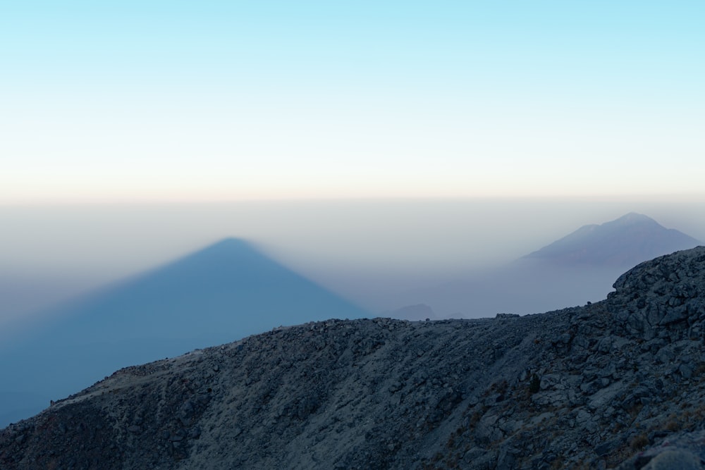 una persona parada en la cima de una montaña