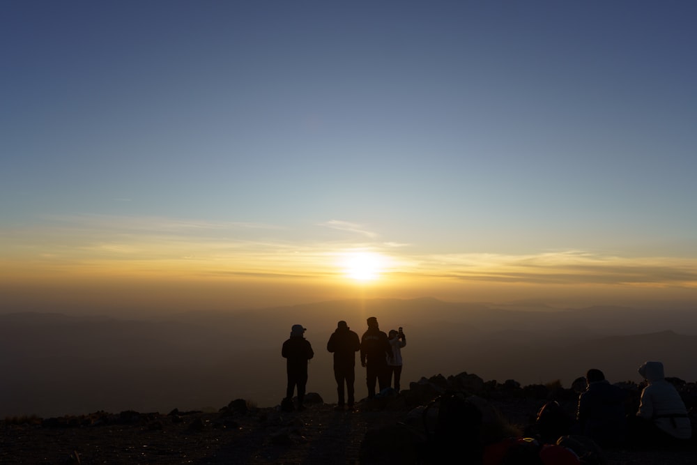 un groupe de personnes debout au sommet d’une montagne