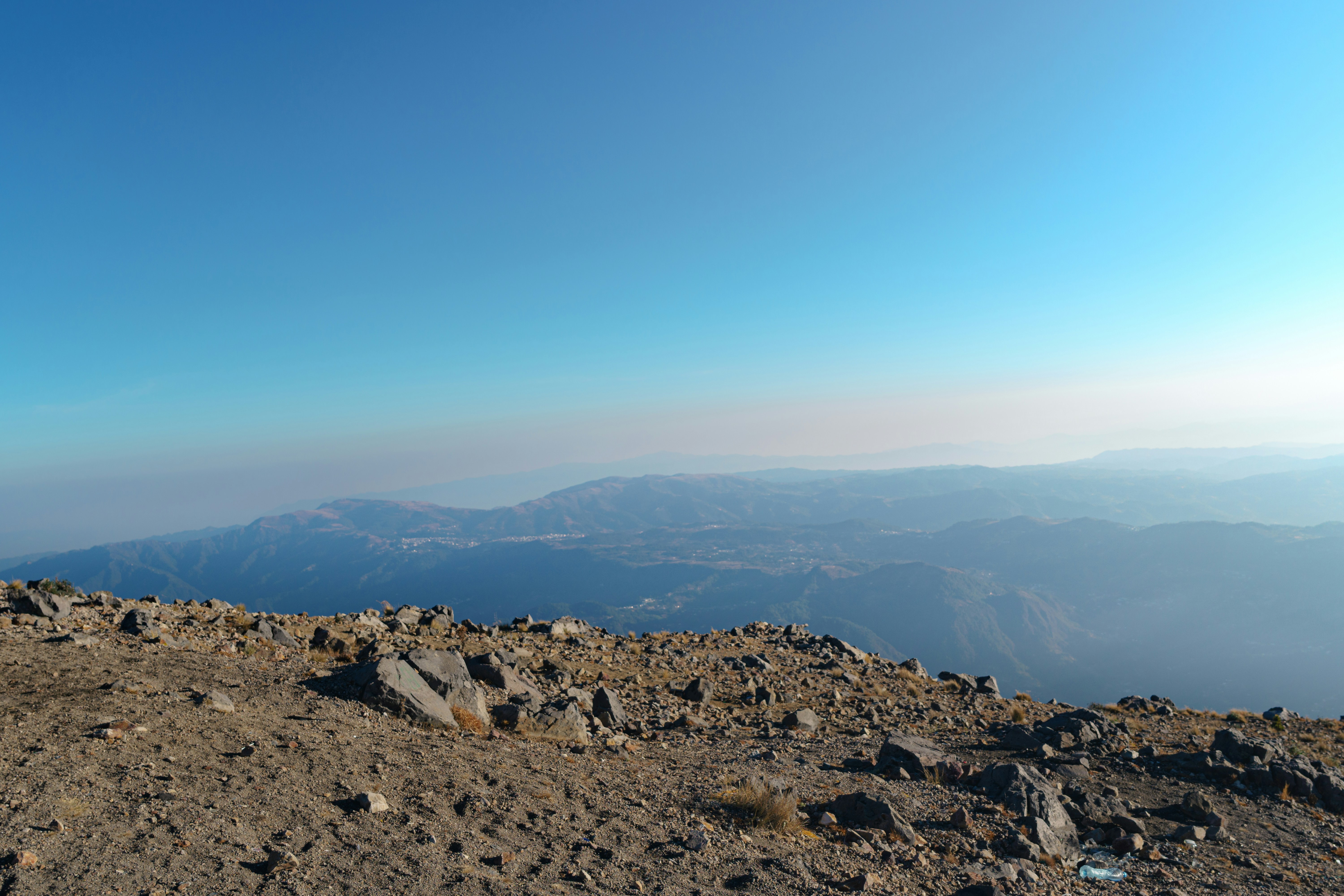 a man standing on top of a rocky mountain, Photographic series documenting the adventure of climbing Tajumulco Volcano, San Marcos, Guatemala. Showcasing diverse landscapes, sunsets, mountain terrains, plants, and fellow adventurers. Focusing on outdoor sports and the beauty of nature through adventure and travel photography.