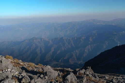 a man sitting on top of a mountain next to a dog