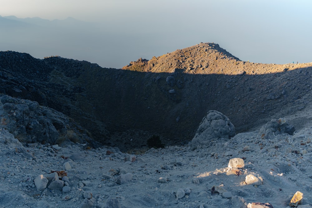 a rocky area with a mountain in the background