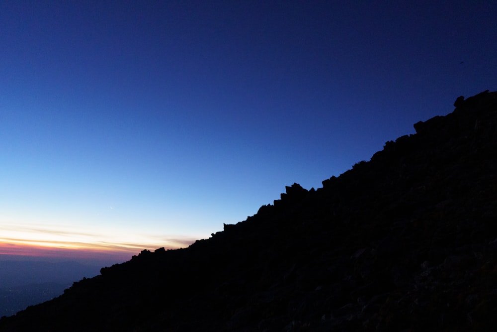 a person standing on top of a mountain at night