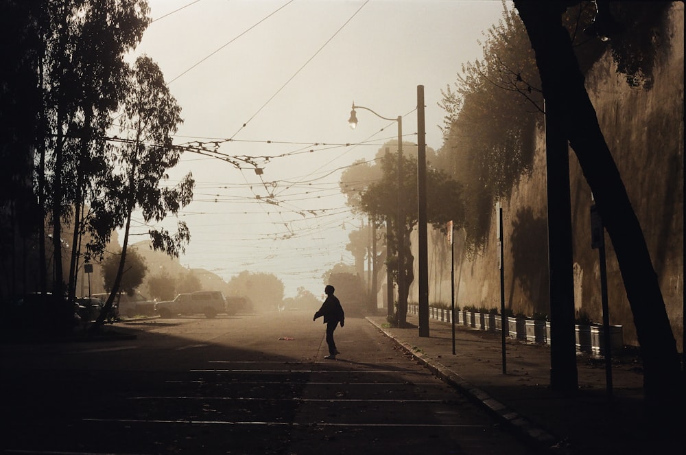 a person walking down a street in the fog