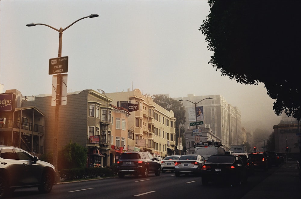 a street filled with lots of traffic next to tall buildings