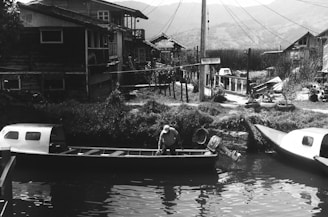 a black and white photo of a man in a boat