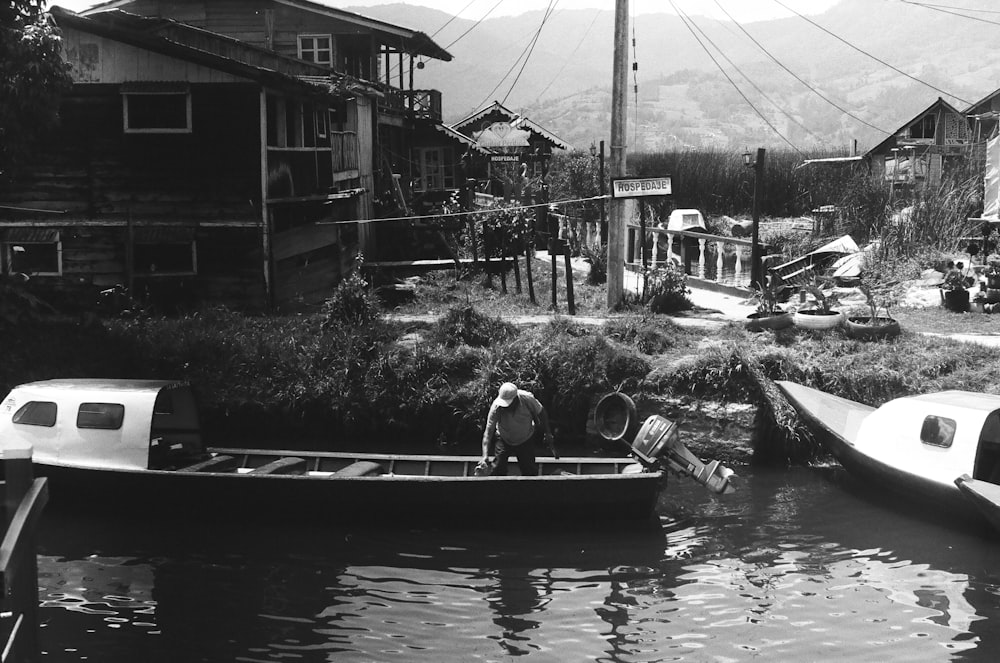 a black and white photo of a man in a boat