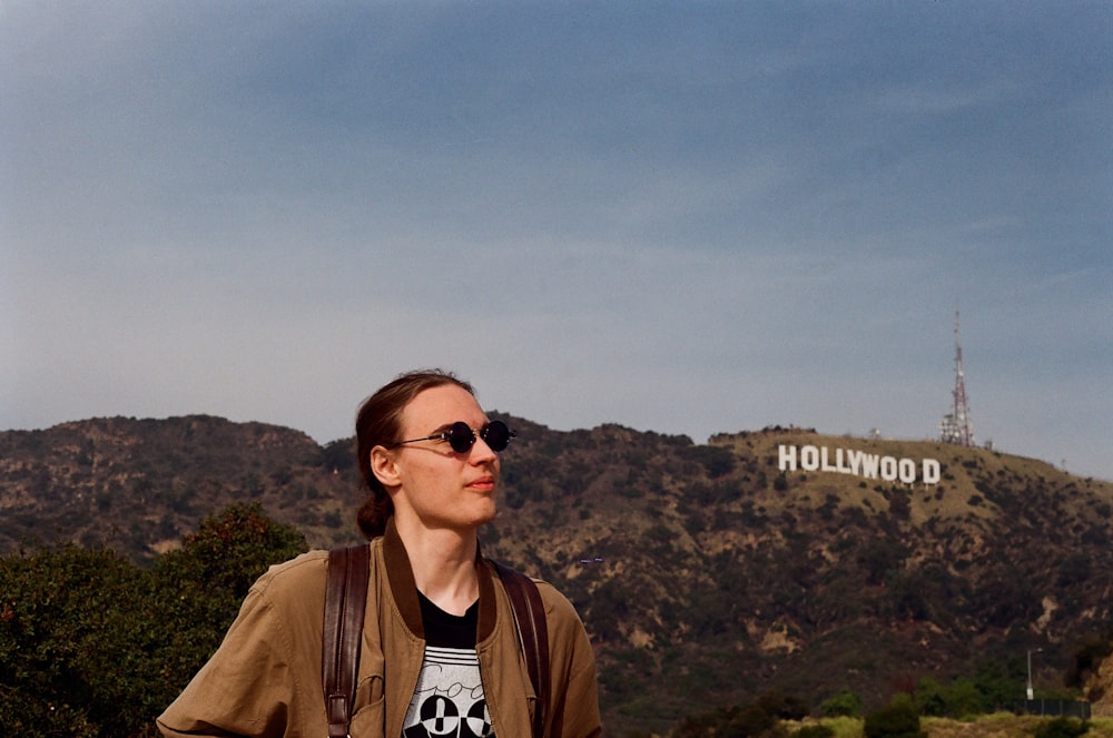 a woman standing in front of a hollywood sign
