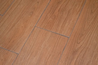 a close up of a wooden floor with a white cat laying on it