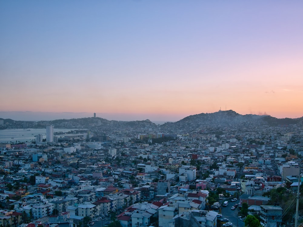 a view of a city at sunset from a hill