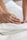 a close up of a person laying in a bed with a towel