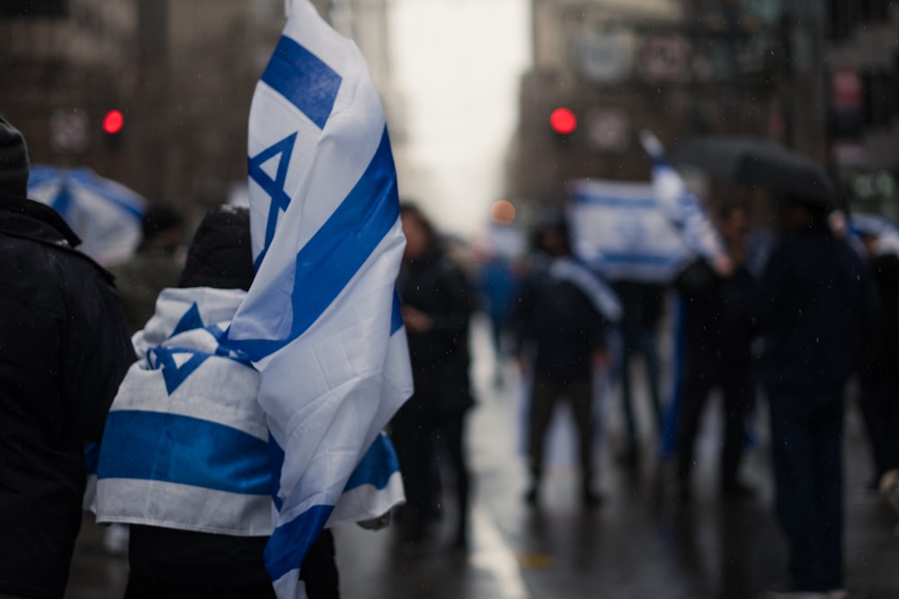 a group of people walking down a street holding flags