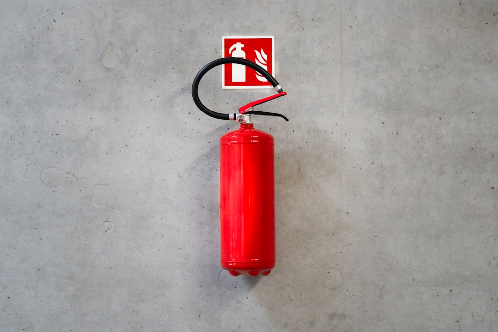 a red fire extinguisher hanging on a wall