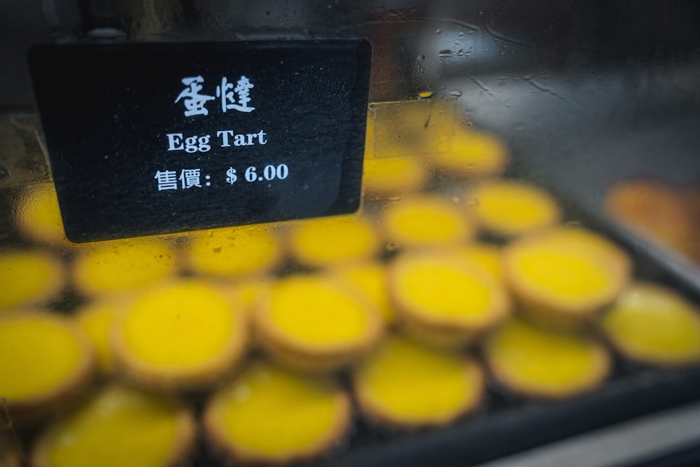 a display case filled with lots of yellow cupcakes