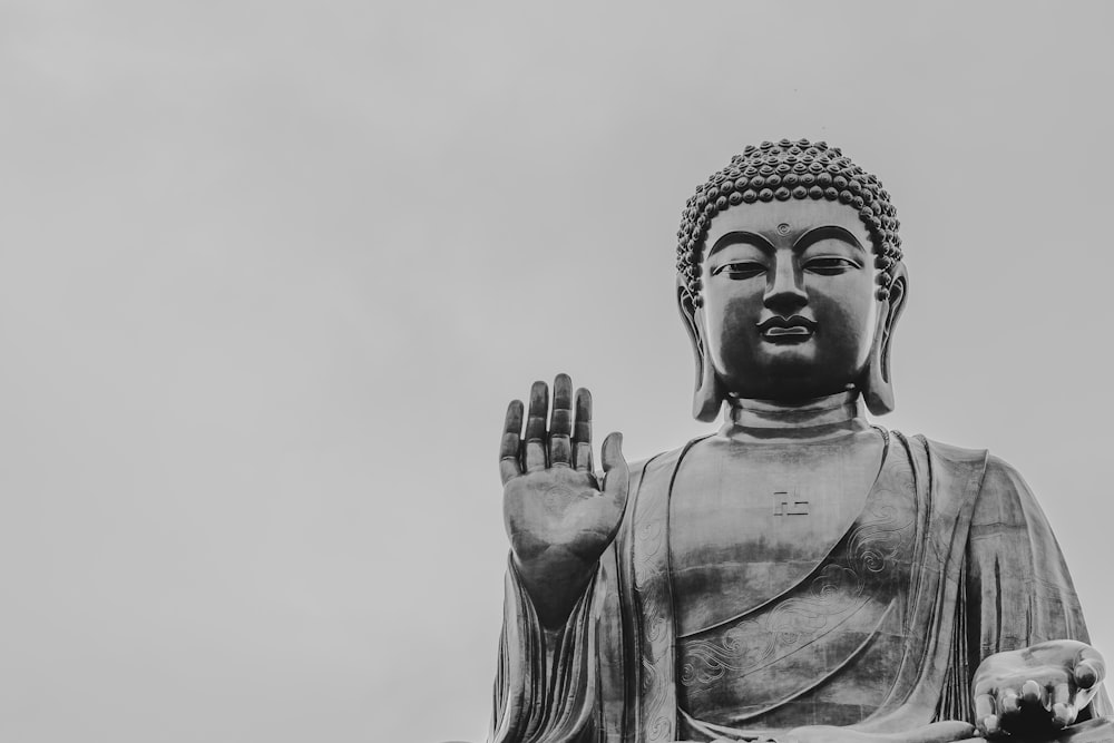 a large buddha statue with a dog sitting next to it