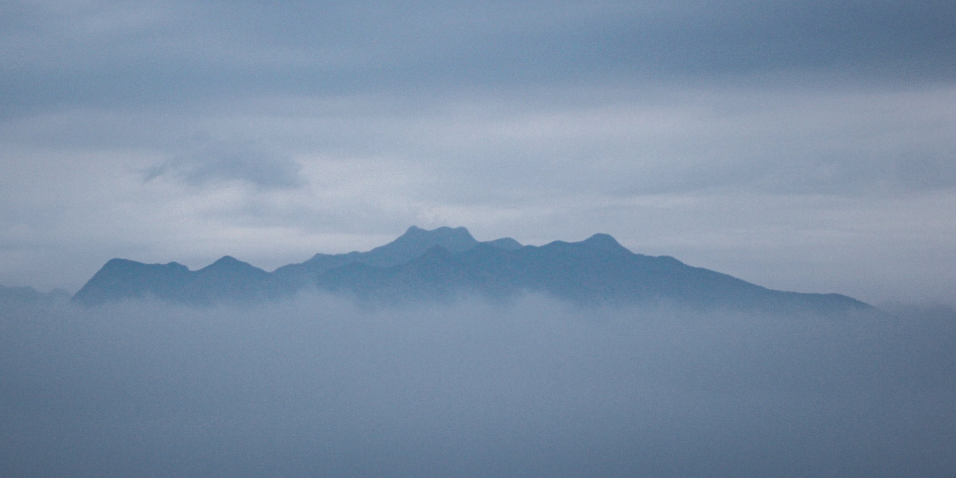 a view of a mountain range in the fog