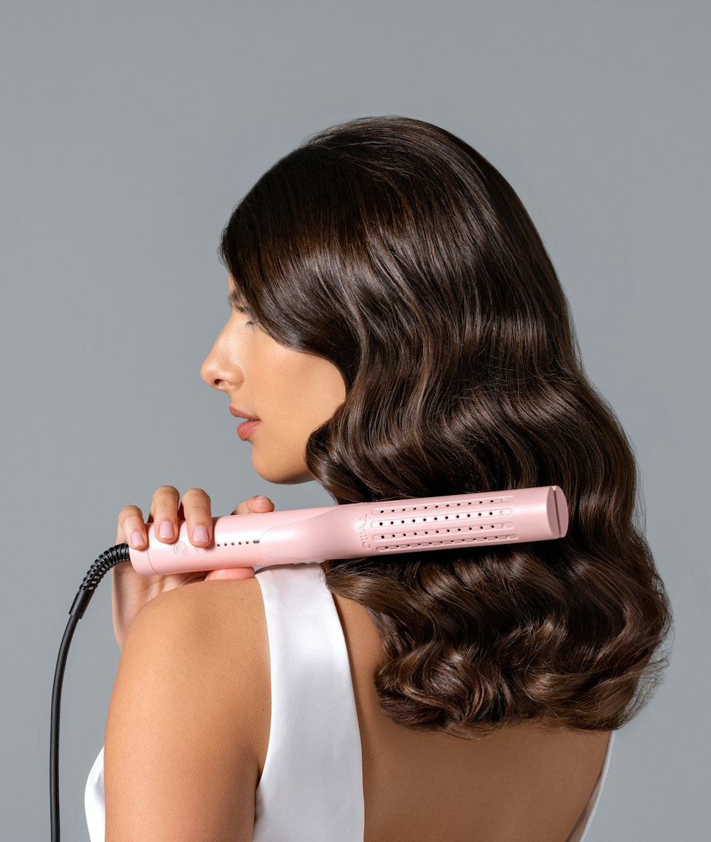 a woman using a hair dryer on her back