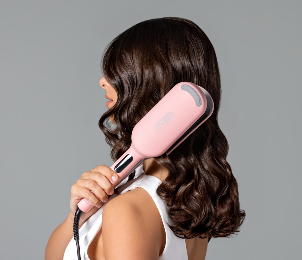 a woman blow drying her hair with a hair dryer