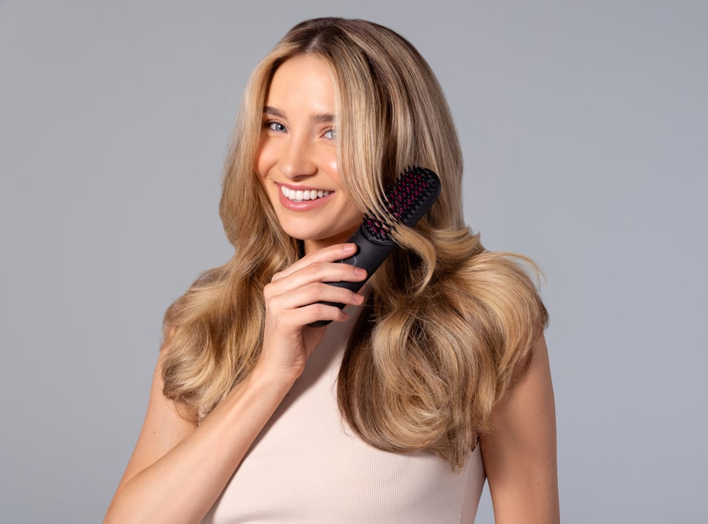 a woman holding a hair brush in her hand