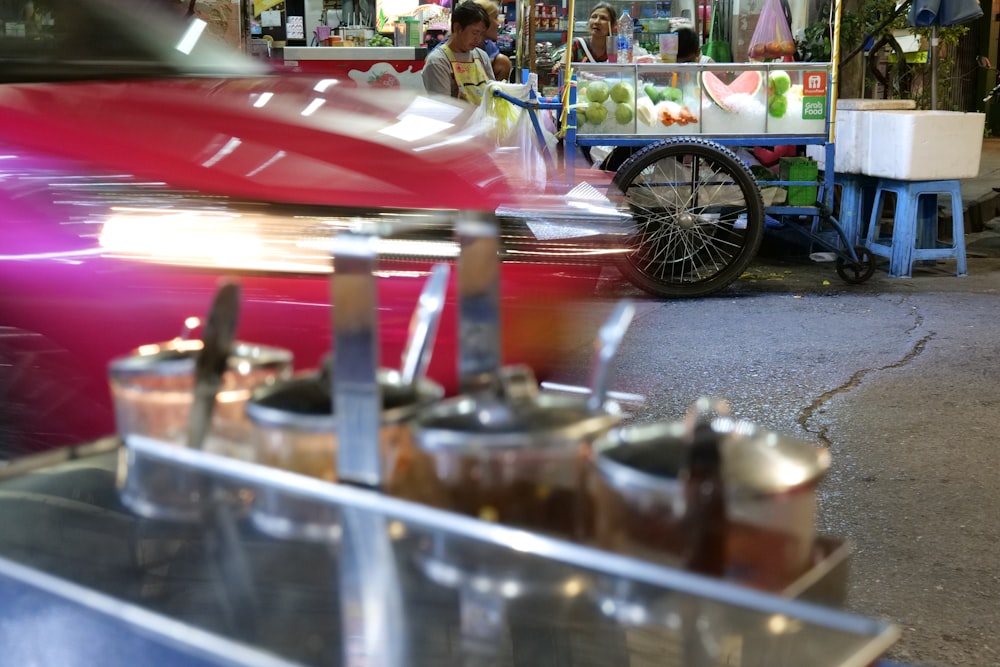 a red car parked in front of a food stand