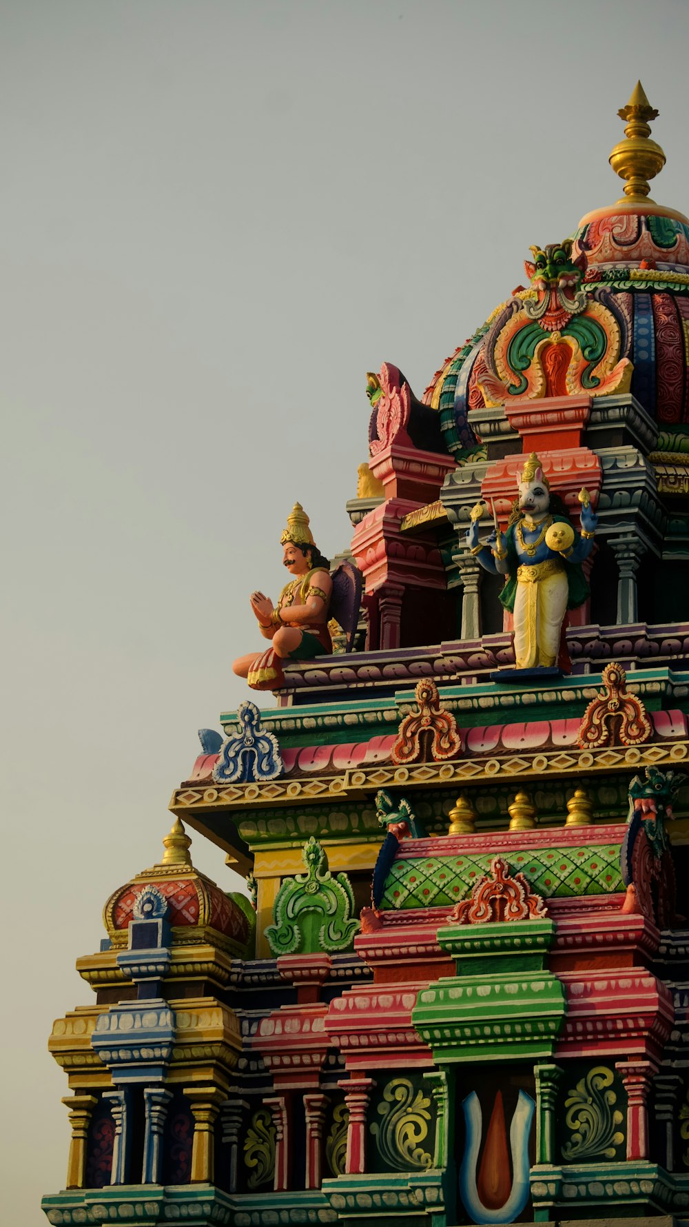 a colorful building with statues on top of it