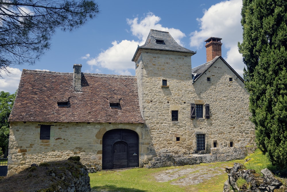 ein altes Steingebäude mit einem Turm und einer Tür