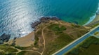 an aerial view of a road near the ocean