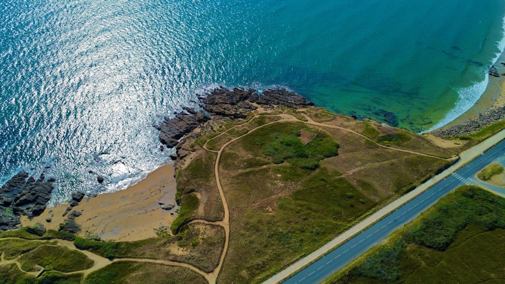 an aerial view of a road near the ocean