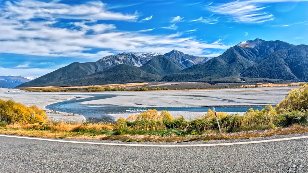 a curved road with mountains in the background