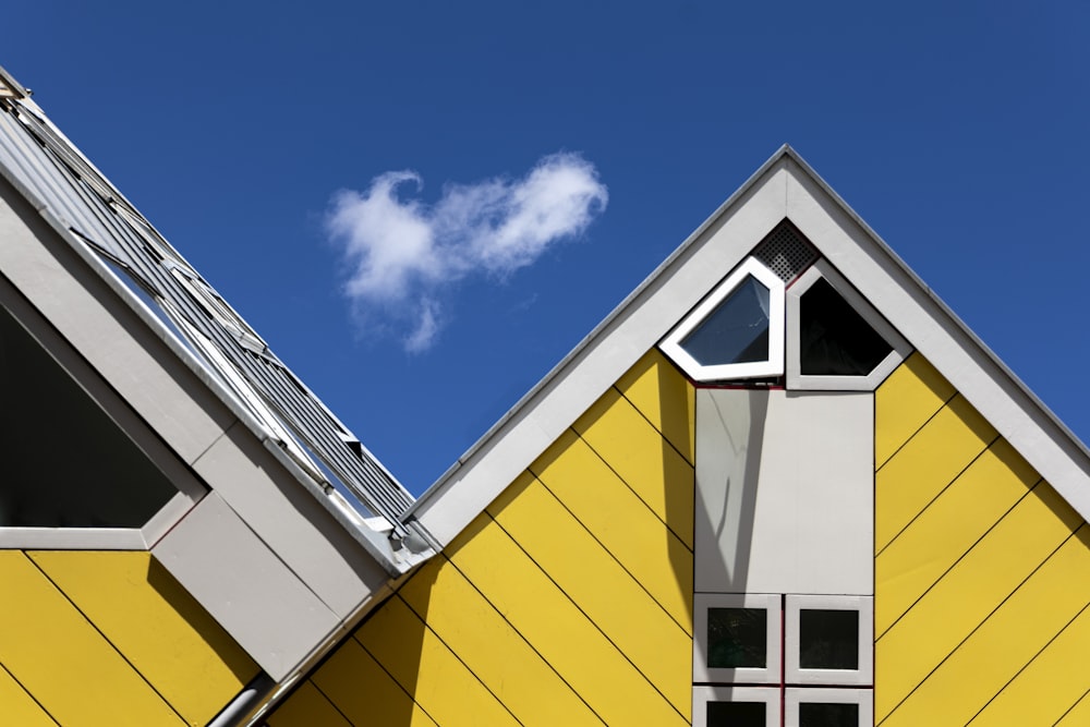 a yellow house with a heart shaped cloud in the sky