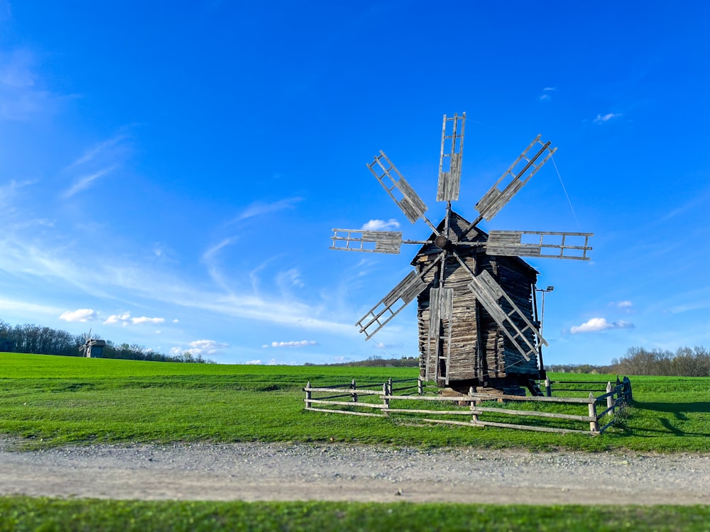 a windmill sitting on top of a lush green field