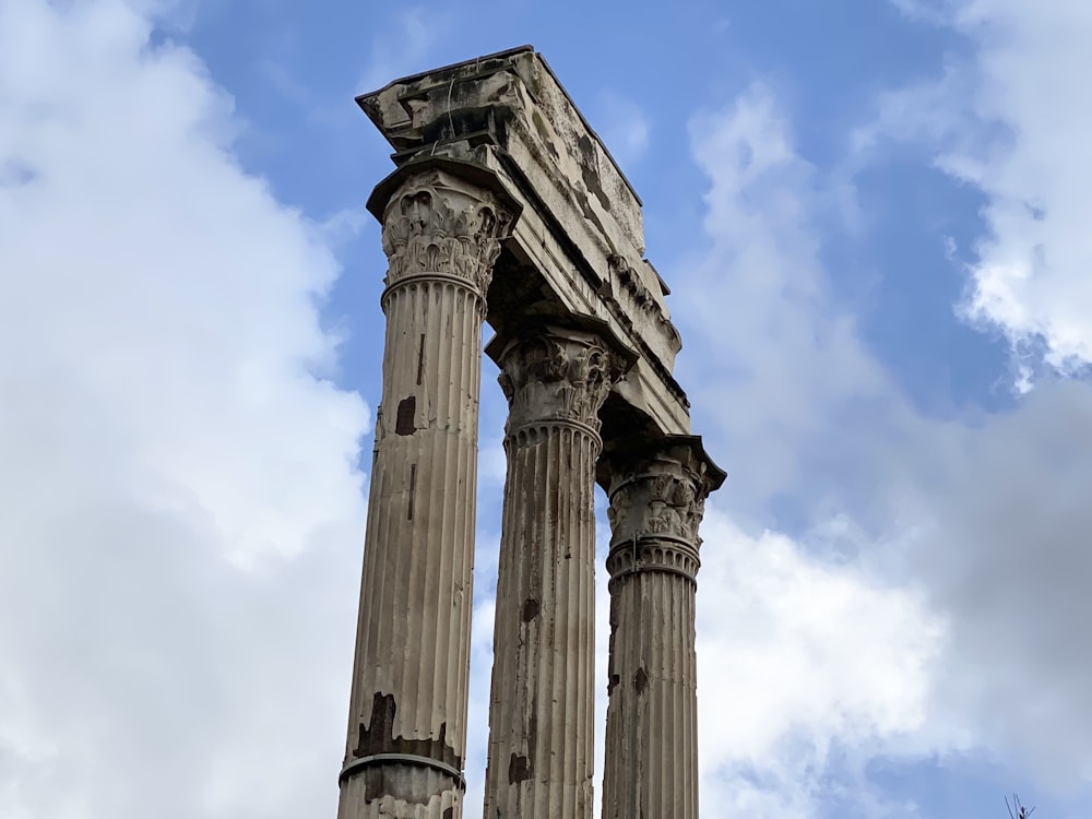 a couple of tall pillars sitting under a cloudy blue sky