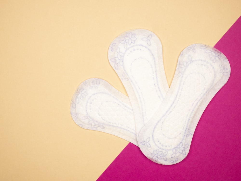 a pair of white socks sitting on top of a pink and yellow table