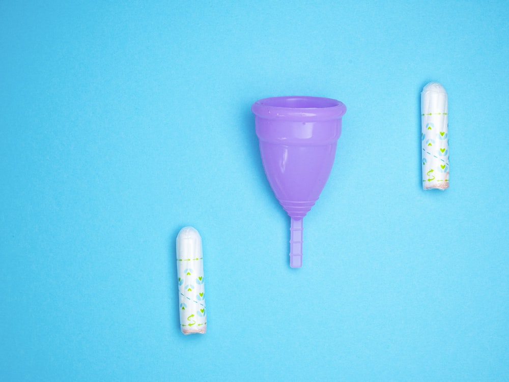 a purple cup and two white cups on a blue background