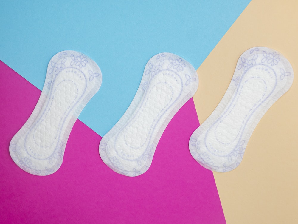 a pair of white socks sitting on top of a pink and blue background
