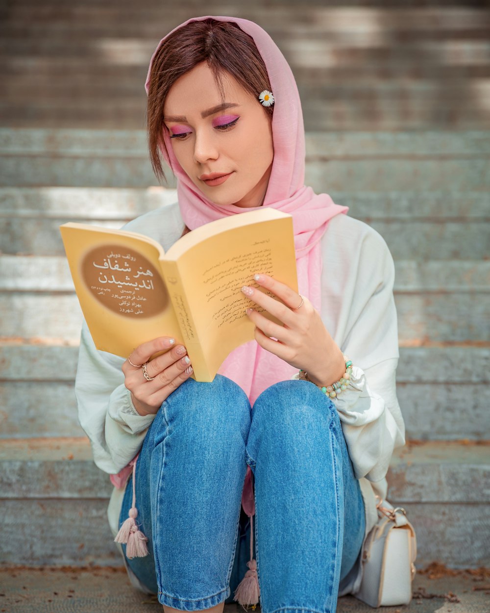 a woman in a hijab is reading a book