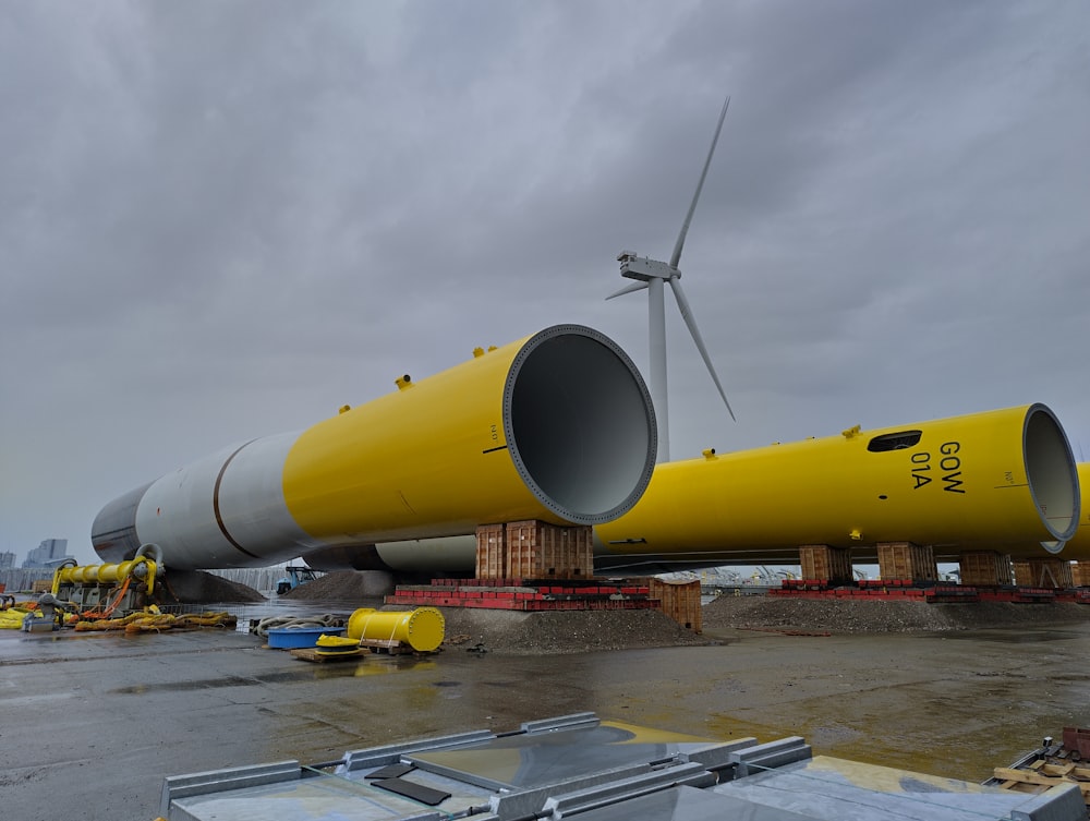 a yellow wind turbine sitting on top of a tarmac
