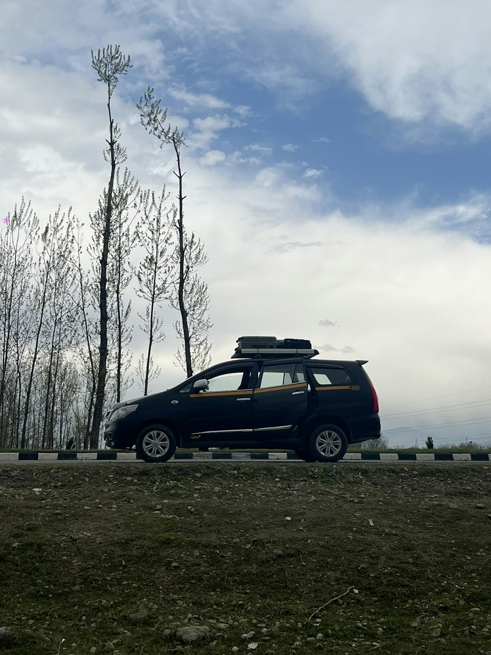 a small black car with a surfboard on top of it