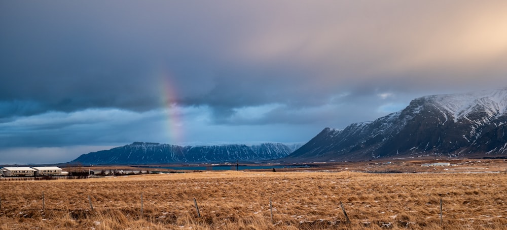 a rainbow in the distance with mountains in the background