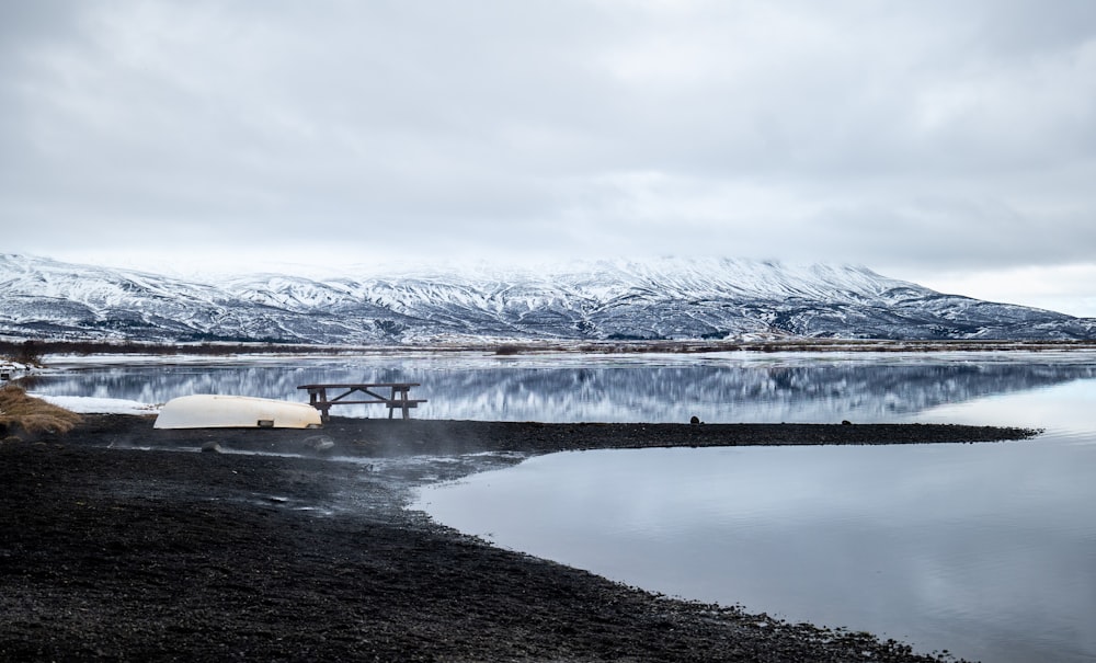 a tent is set up on the shore of a lake