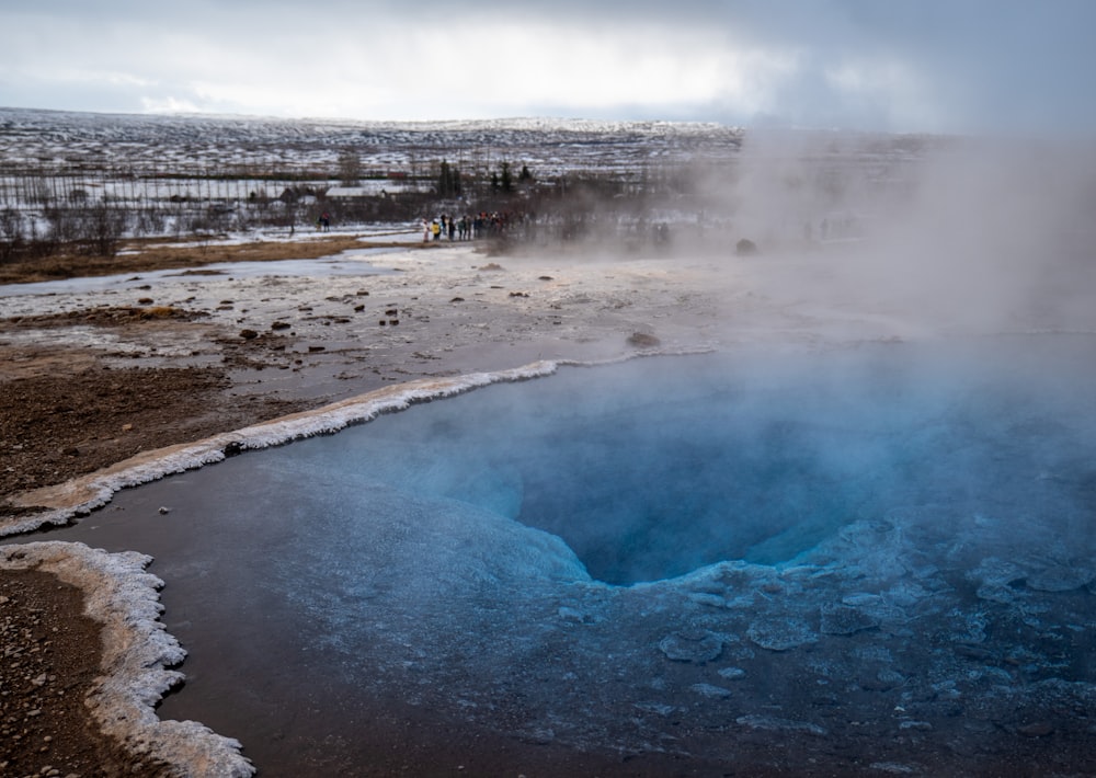 a blue pool of water surrounded by snow