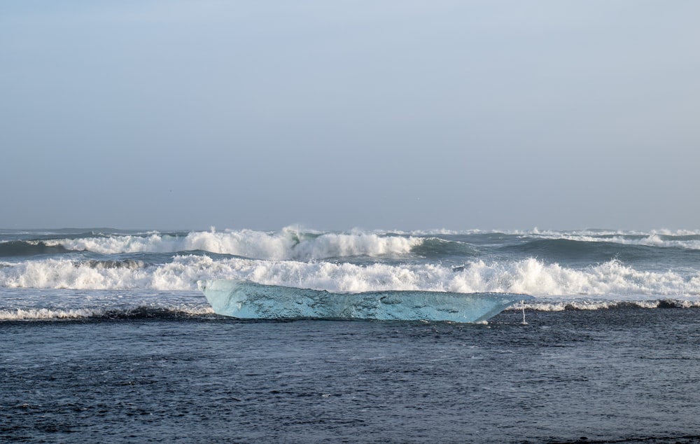 a large iceberg floating in the middle of the ocean