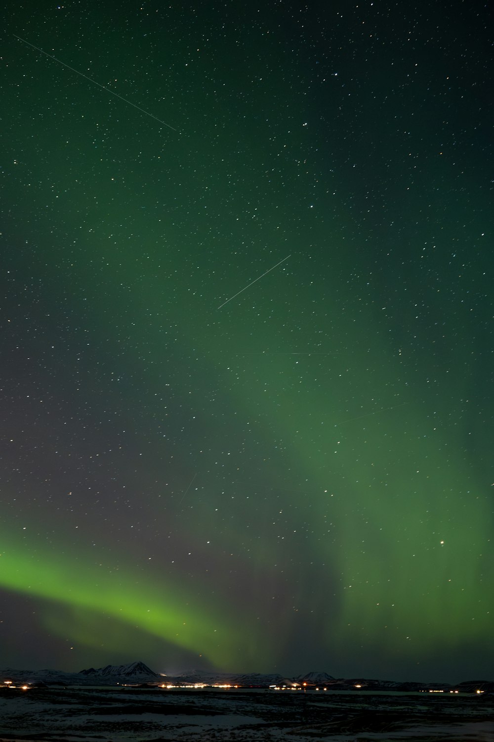 a green and white aurora bore is in the sky