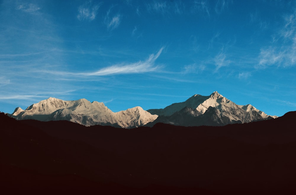 a mountain range with a blue sky in the background